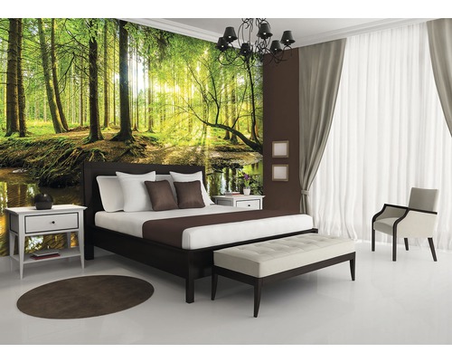 Slaapkamer met fotobehang van een bos, bed, nachtkastjes en bank