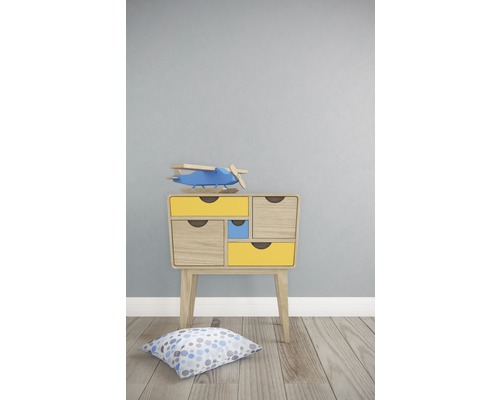 Nachtkastje met laden en speelgoedvliegtuig in kinderkamer.