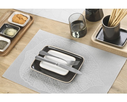 Tafeldecoratie met borden, bestek en snacks op placemats