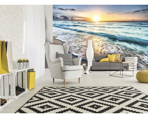 Woonkamer met fotobehang van een zonsopgang aan zee, fauteuil en vloerkleed