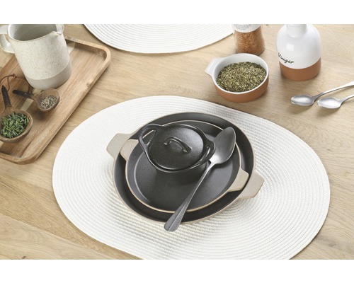 Gedekte tafel met placemats, borden, kommen en lepels.