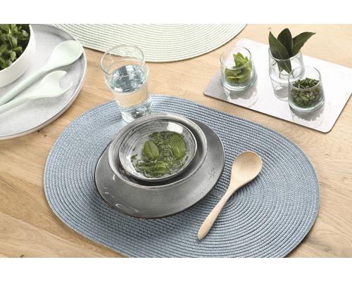 Tafeldecoratie met placemats, servies, glas en kruiden op een houten tafel