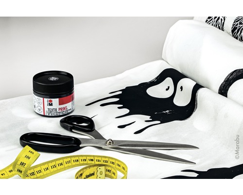 Textielverf, schaar en meetlint op een stof met patroon