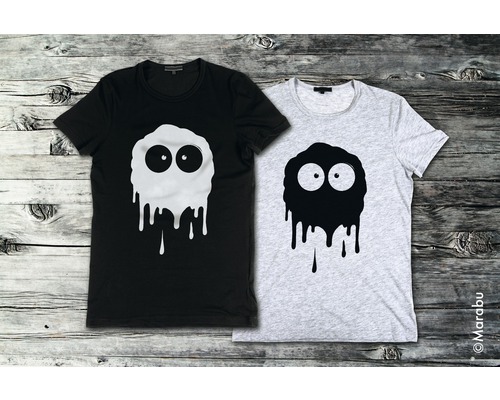 Twee T-shirts met monstermotief op houten achtergrond