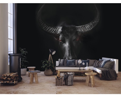 Woonkamer met fotobehang van een buffel, houtkachel, houtblokken en bank