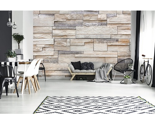 Woonkamer met bank, stoelen, tafel, fiets en een wand met steenlook