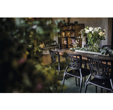 Scene met eettafel, stoelen, bloemdecoratie en glazen