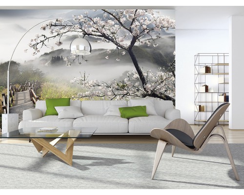 Woonkamer met foto van behang met een landschap met boom en brug