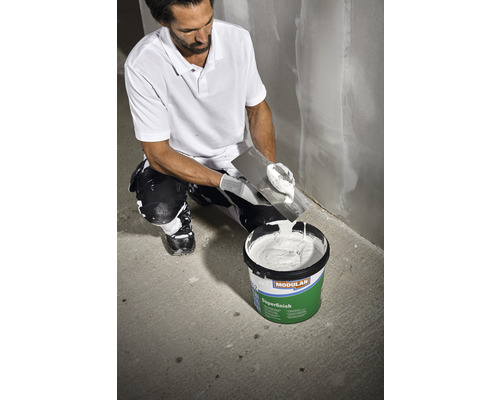 Ambachtsman met plamuurmes en emmer Modulan Superfinish vulmiddel