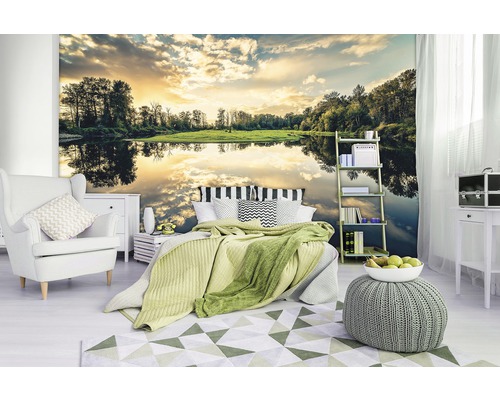 Slaapkamer met fotobehang van een meer bij zonsondergang, fauteuil, bed, vloerkleed en bijzettafel