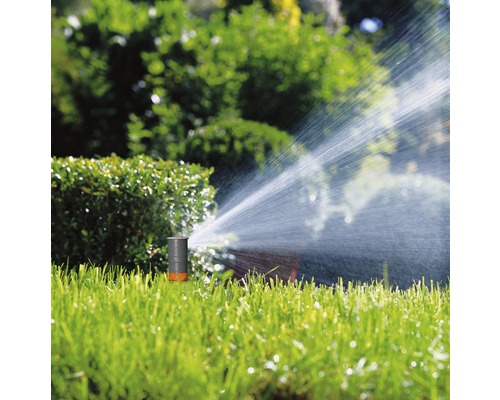 Tuinsproeier besproeit het gazon in de tuin.