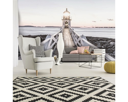 Woonkamer met fotobehang vuurtoren, fauteuil, bank, tapijt en bijzettafel.