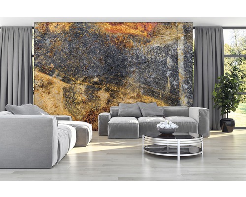 Woonkamer met grijze banken en een fotobehang met steenmotief