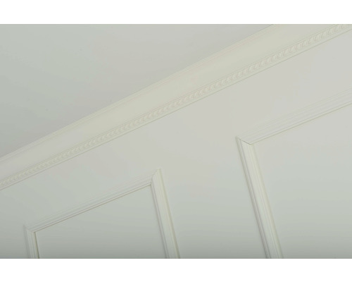 Detail van een wand met sierlijsten en lambrisering