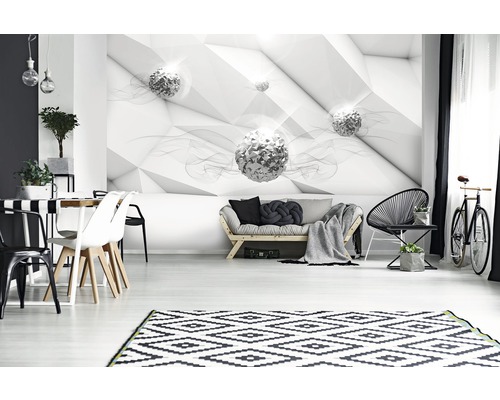 Woonkamer met geometrisch behang, bank, stoelen en vloerkleed