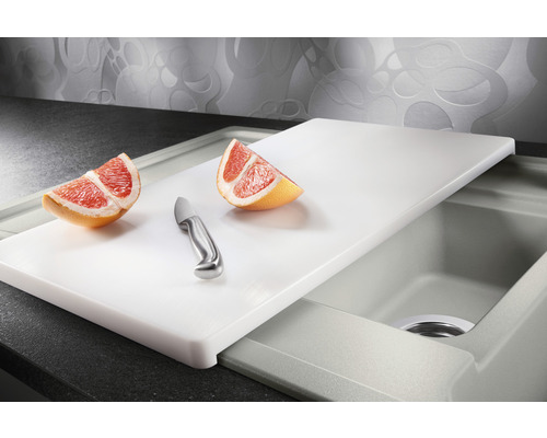 Spoelbak met snijplank, mes en stukken grapefruit