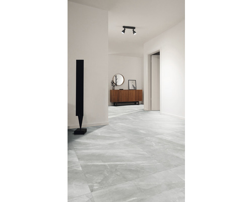 Lichte hal met vloertegels in marmerlook, dressoir en sculptuur.