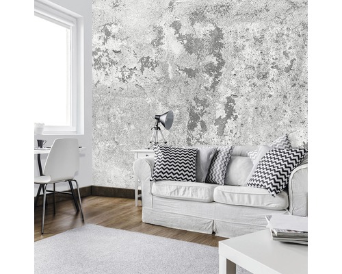 Woonkamer met bank, tafel, stoel, lamp en betonnen wandbekleding