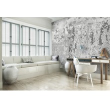 Woonkamer met raam, bank, bureau en betonnen wandbekleding