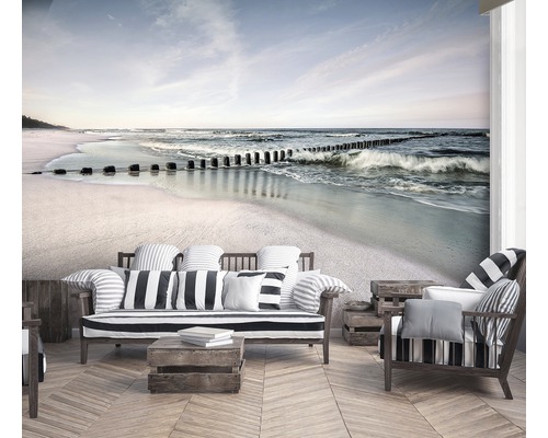 Woonkamer met fotobehang waarop een strand met golven en houten palen te zien is