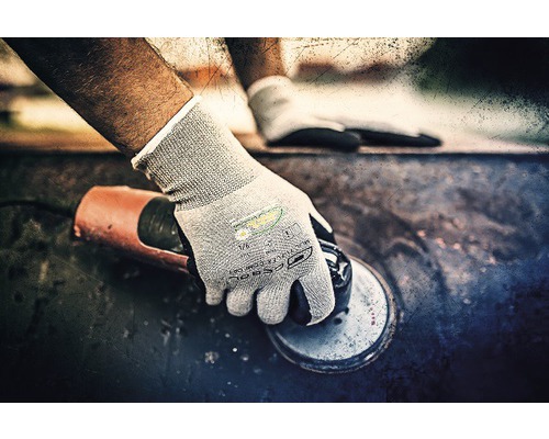 Een persoon die met een haakse slijper werkt en daarbij veiligheidshandschoenen draagt