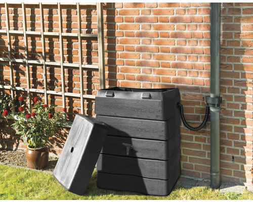 Regenwaterreservoir met regenwaterafvoer tegen een bakstenen muur