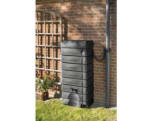 Kunststof regenton met kraan tegen een huismuur