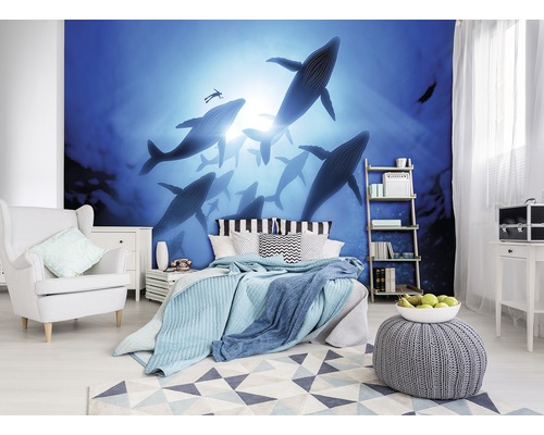 Slaapkamer met fotobehang dat een groep walvissen in de oceaan voorstelt