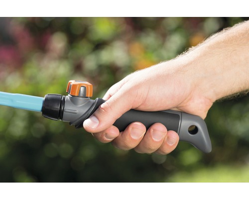 Hand houdt een tuinslangaansluitstuk met regelaar vast