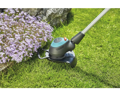 Gras trimmer in gebruik naast bloembed