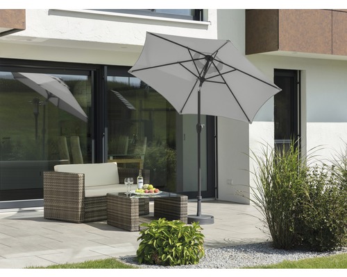Scene met een parasol, loungeset en tuintafel op een terras.