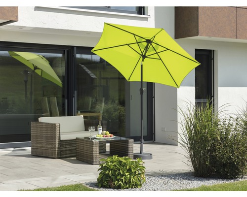 Scène met gele parasol, rotan zitgroep en tafel op een terras
