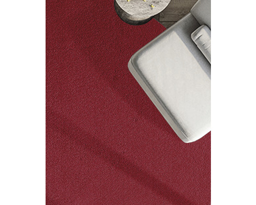 Close-up van een rood tapijt naast een grijze bank en een bijzettafel