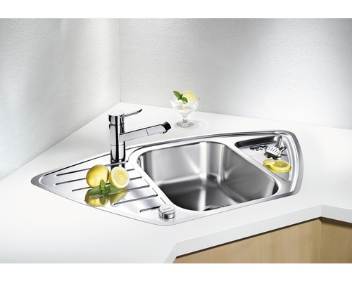 Roestvrijstalen hoekspoelbak met kraan en afdruiprek op een aanrecht.