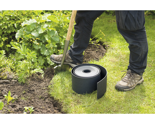 Tuinlandschap met gazonrand, spade en persoon