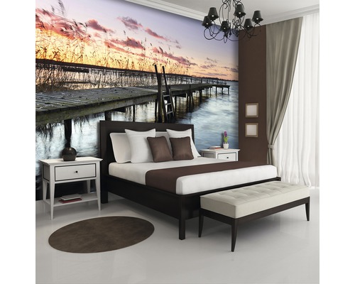 Slaapkamer met fotobehang van steiger aan meer bij zonsondergang
