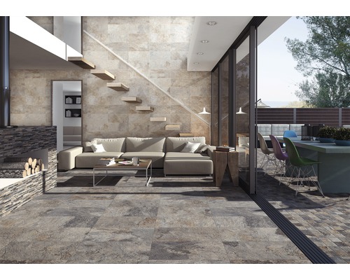 Woonkamer met tegelvloer, bank, trap en open haard