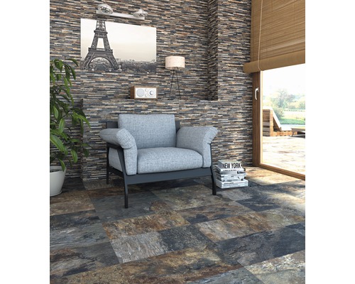 Woonkamer met natuurstenen muur en vloertegels met steenlook, fauteuil en decoratie