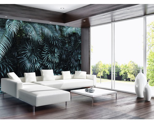 Lichte woonkamer met witte hoekbank, salontafel en decoratieve vazen tegen een junglebehang.