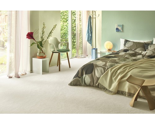 Lichte slaapkamer met bed, stoel, raam en vloerkleed