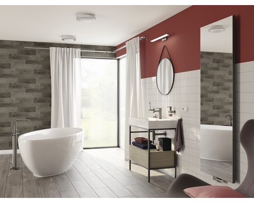 Lichte badkamer met bad, wastafel en spiegel