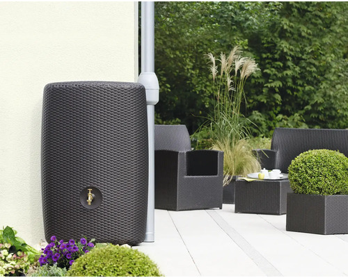 Regenton in rotanlook met kraan in de tuin