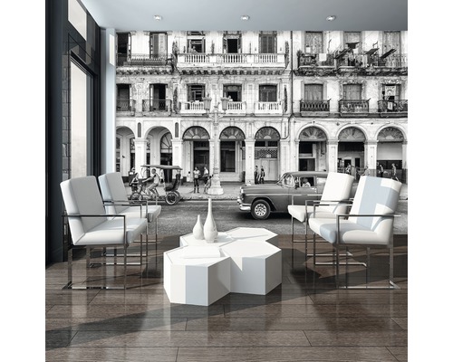 Woonkamer met fotobehang van een stadsgezicht, fauteuils en tafel