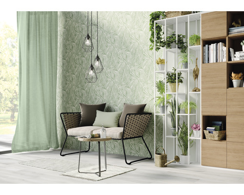 Woonkamer met bank, tafel, staande kast, decoratie en behang met bladerpatroon