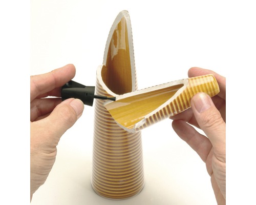 Een gebroken keramiekobject wordt met lijm gerepareerd