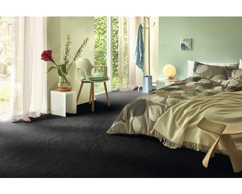 Slaapkamer met donkere vloerbedekking, bed en raam