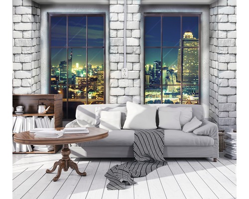 Woonkamer met bank, tafel en uitzicht op de stad bij nacht