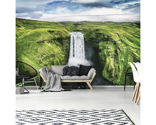 Woonkamer met fotobehang van een waterval in een groen landschap