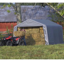 Grijze opslagtent met hooibalen en persoon