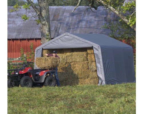 Grijze opslagtent met hooibalen en persoon